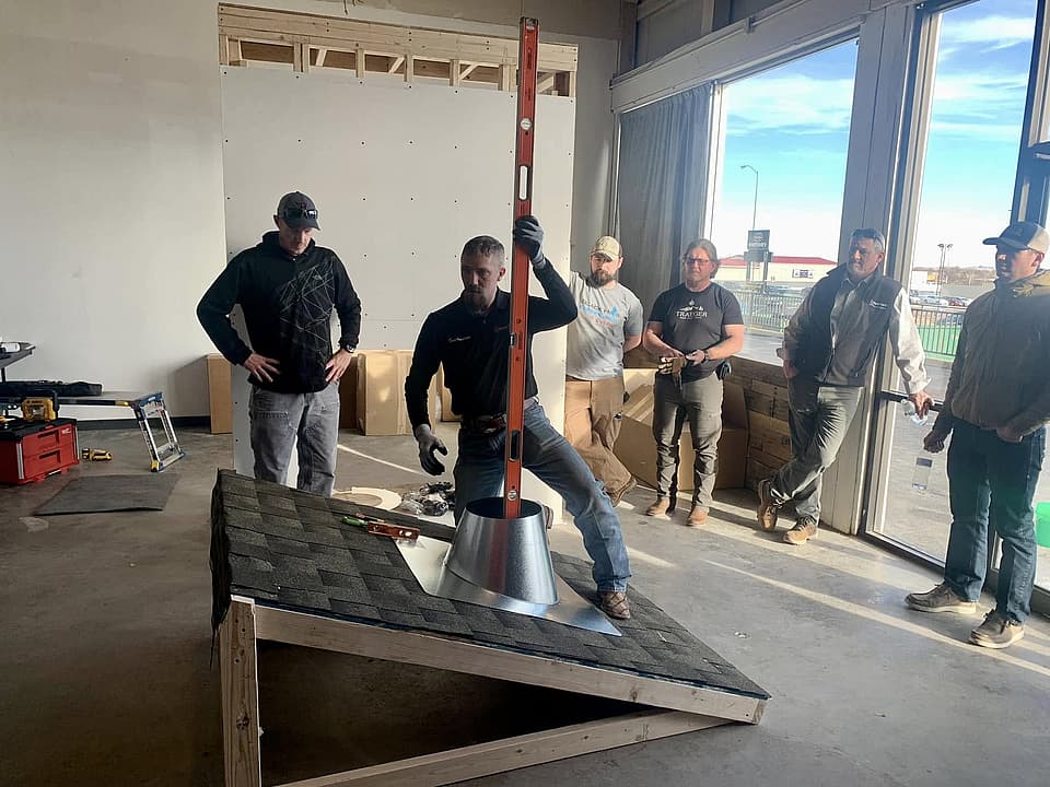 Toasty Chimney owner demonstrating chimney flashing installation on a practice roof during a sweep team training session