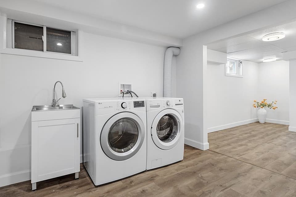 Bright laundry room with a white front-loading washer and dryer side by side
